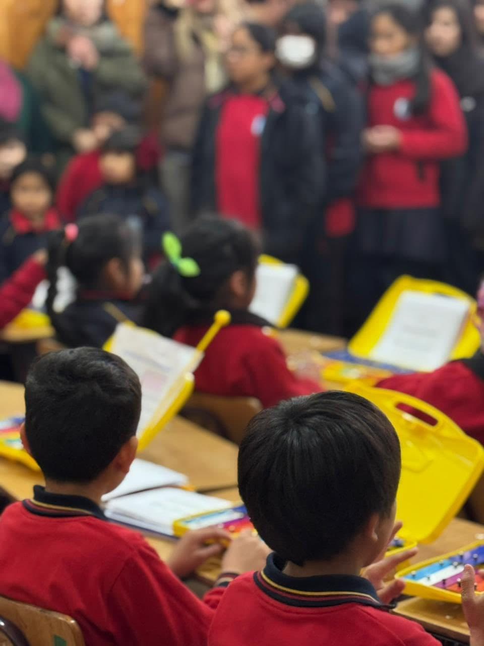 Estudiantes participando en una actividad musical con instrumentos