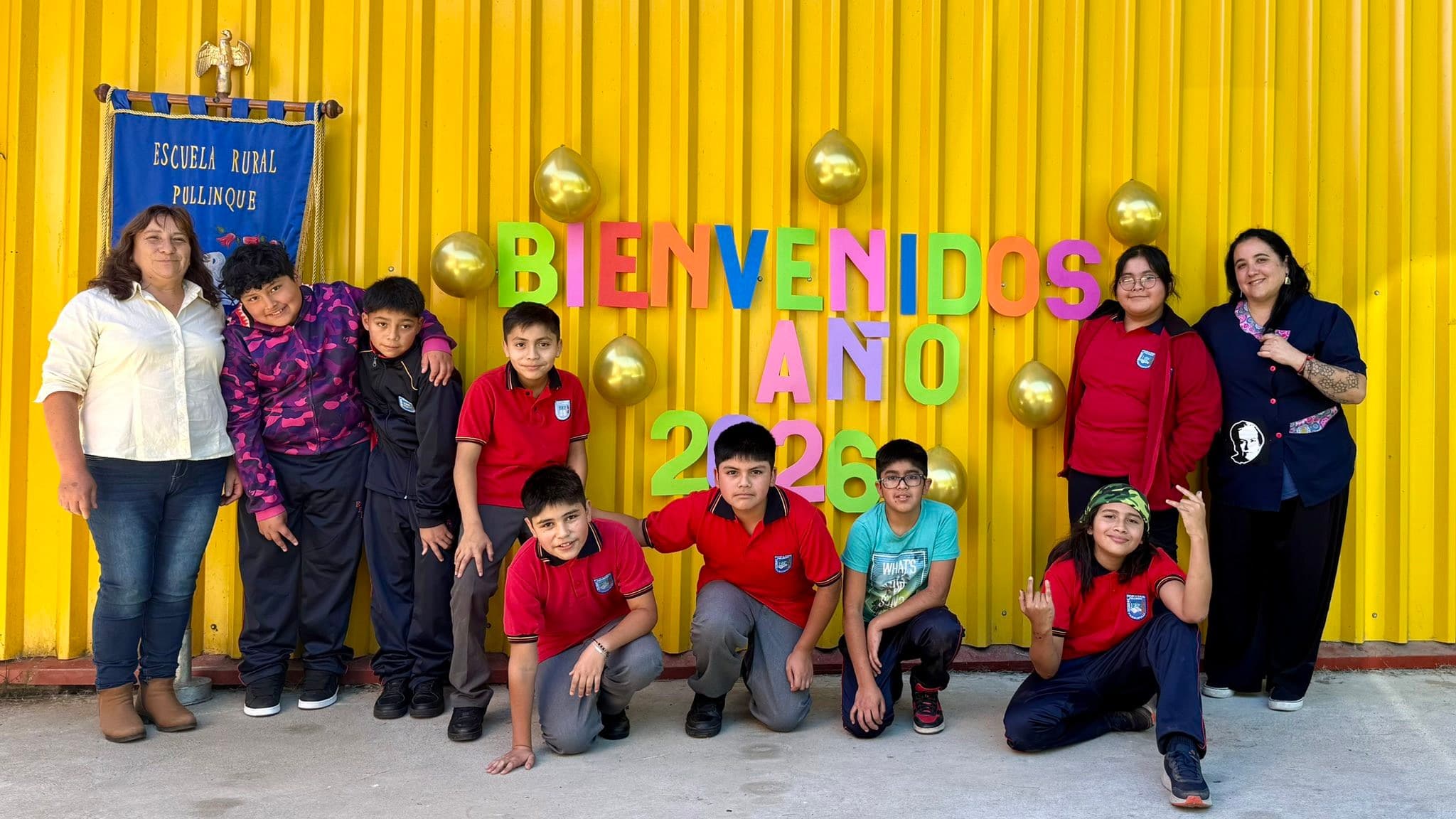 Estudiantes y equipo educativo frente al panel de bienvenida del año escolar 2026
