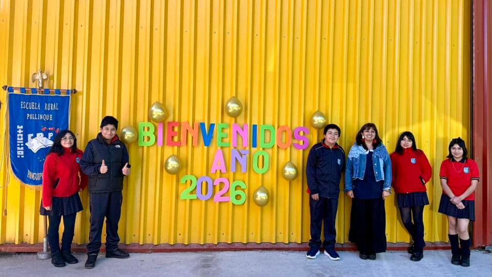 Estudiantes de la Escuela Rural Pullinque junto al pendón institucional en la bienvenida escolar