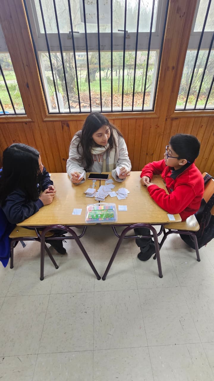 Estudiantes de cuarto básico trabajando en pequeño grupo junto a una integrante de la comunidad educativa