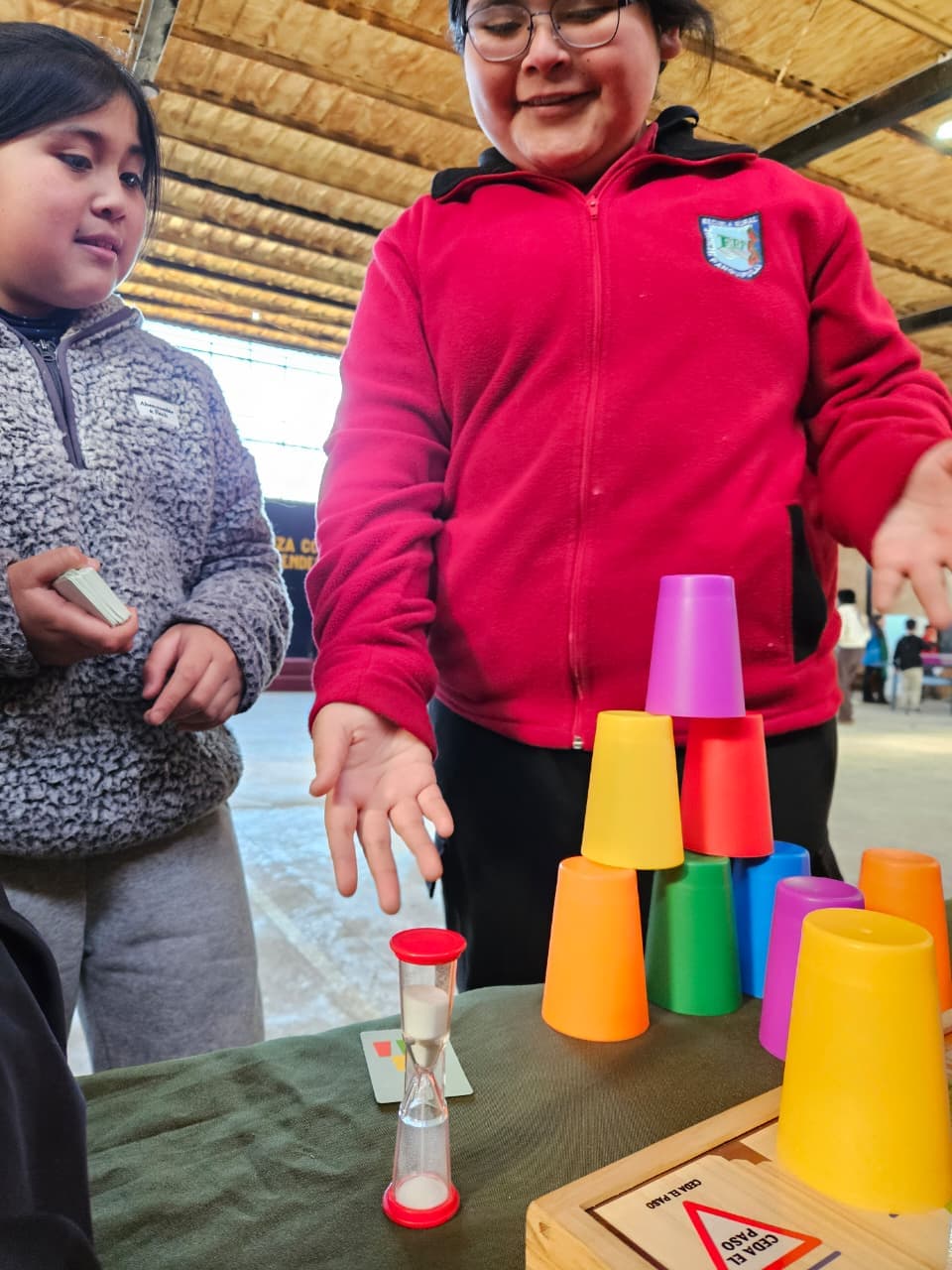 Estudiantes construyendo una torre de vasos en una actividad recreativa