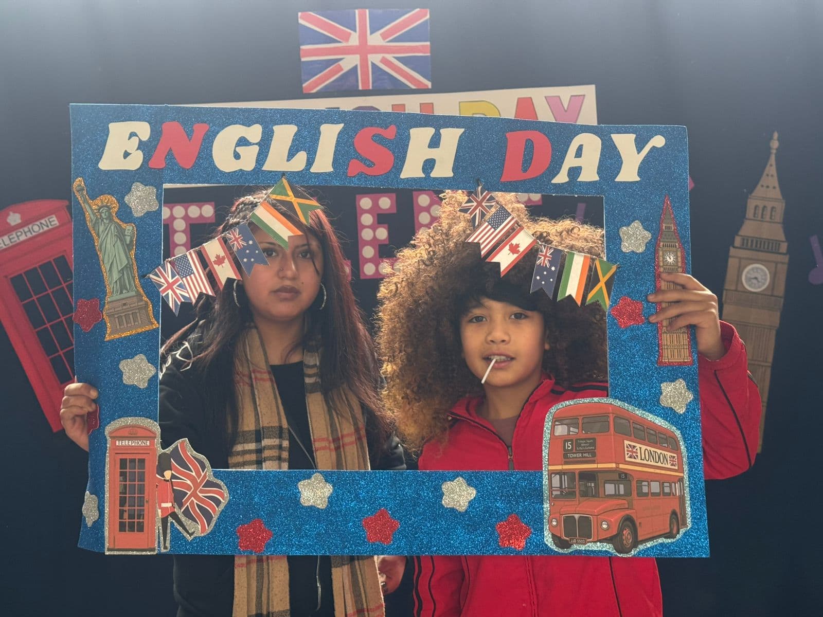 Dos estudiantes con accesorios de caracterización en el espacio de fotografías de English Week