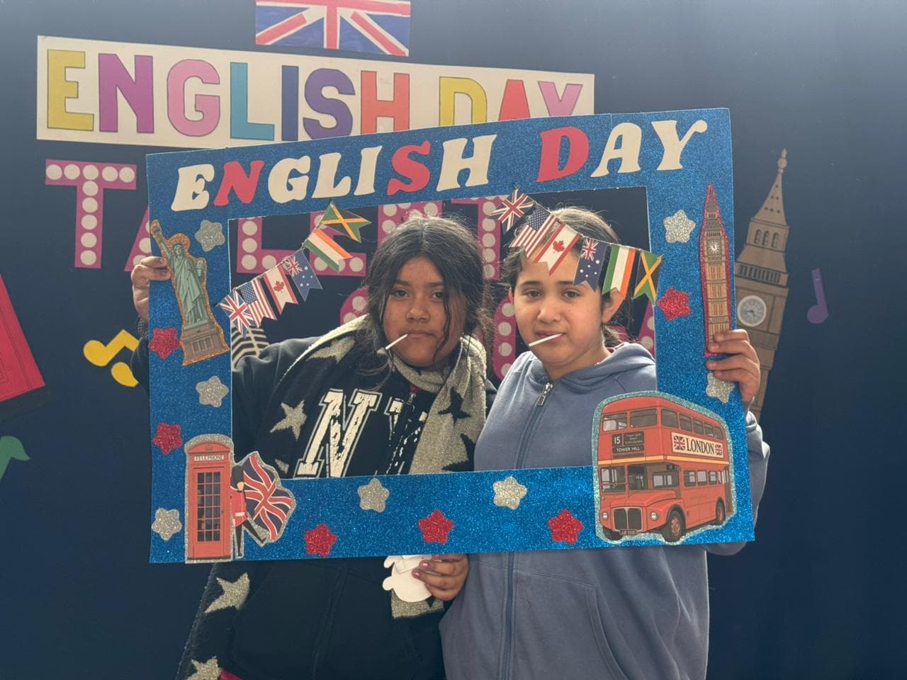 Estudiantes posando con el marco decorado con banderas de distintos países