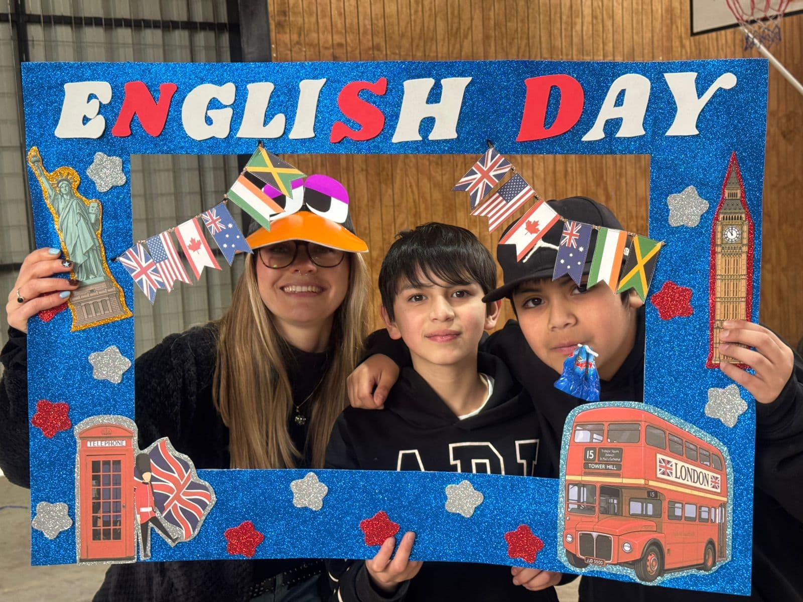 Participantes compartiendo una fotografía con sombreros y el marco English Day
