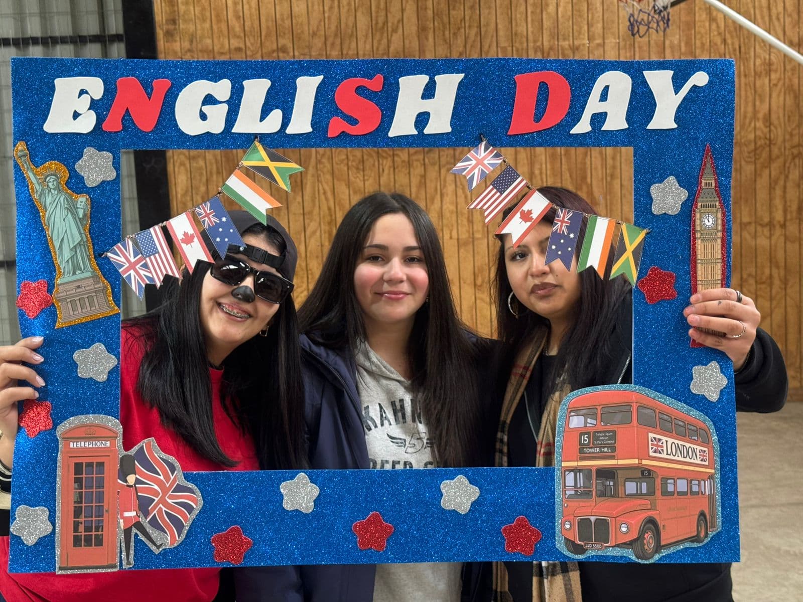 Grupo de participantes frente al marco azul de la celebración de English Week