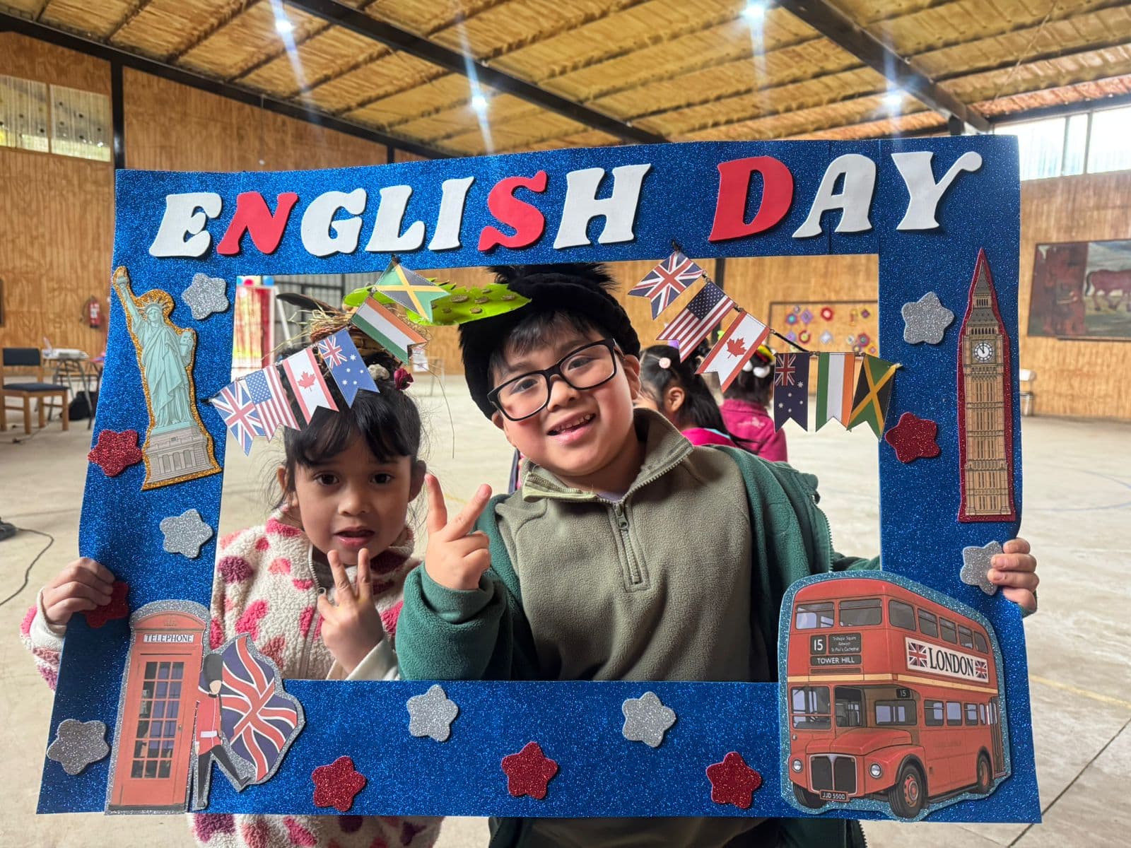 Estudiantes con accesorios creativos posando en el gimnasio durante English Week