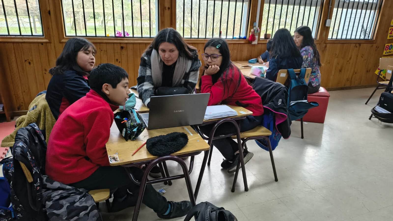 Estudiantes de 4° básico trabajan en grupo una actividad sobre medición junto a una adulta colaboradora