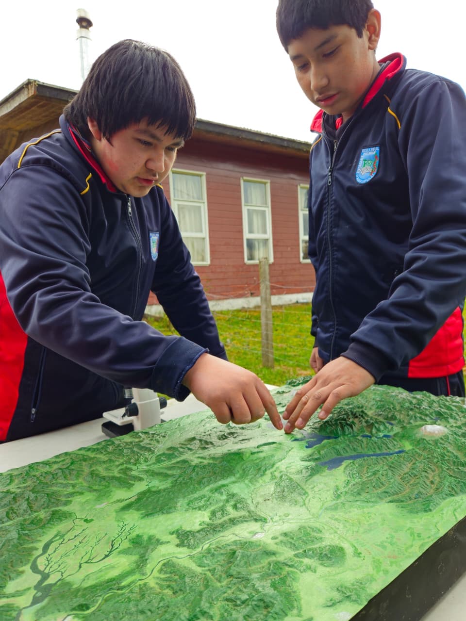 Estudiantes observando el territorio en una maqueta durante la experiencia de educación ambiental