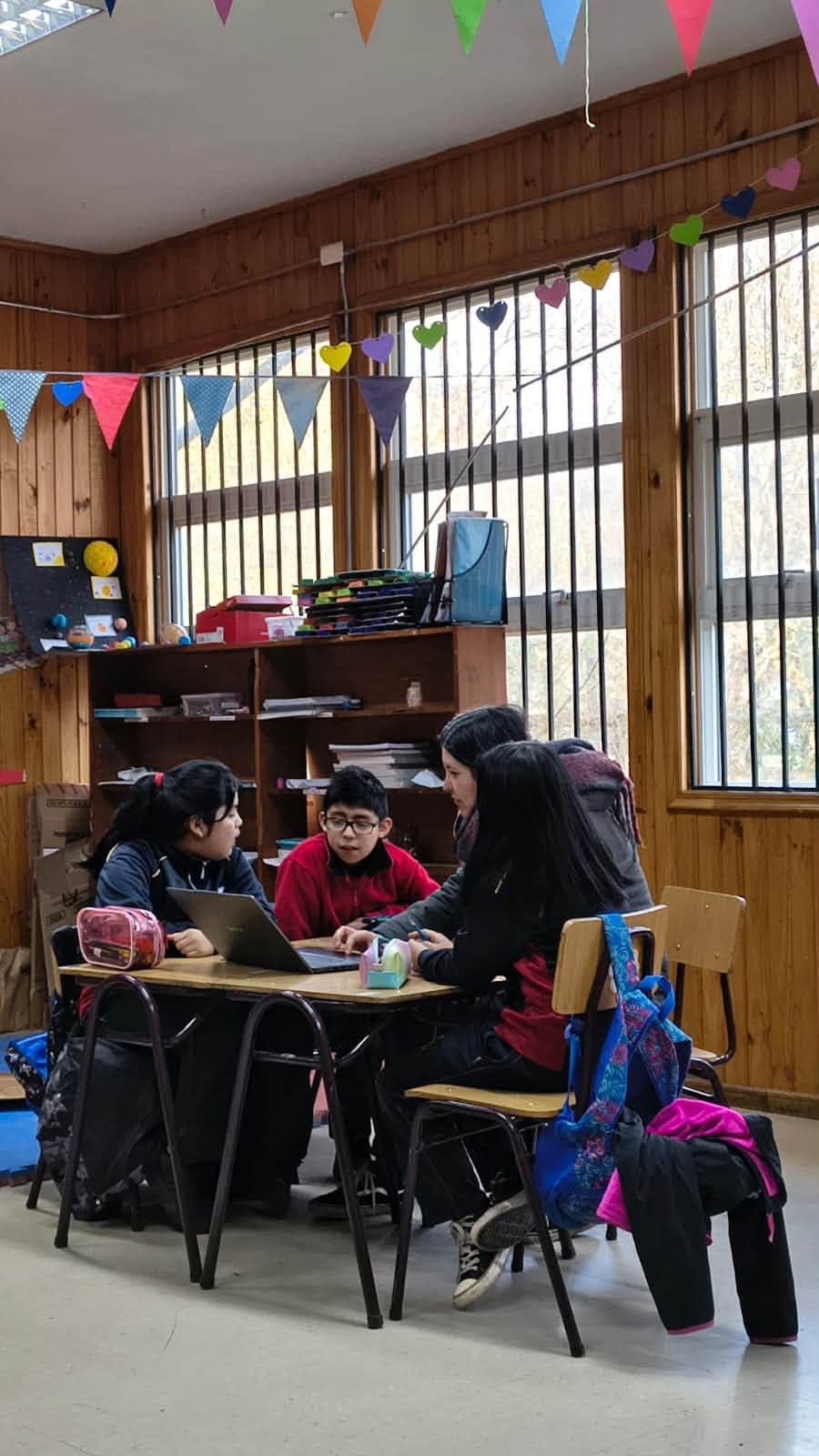 Grupo de estudiantes conversa y trabaja con apoyo de recursos digitales