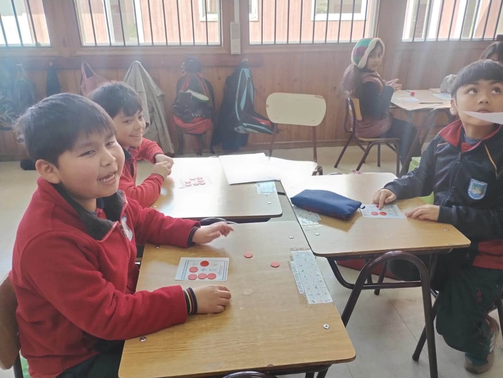Estudiantes utilizan tarjetas y fichas durante el bingo de fracciones